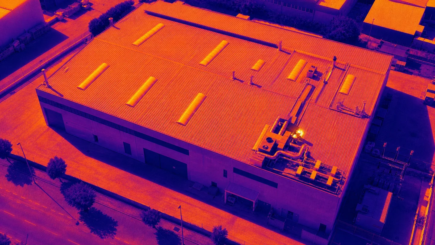 Vista térmica conceptual de la misma cubierta industrial con una anomalía demostrativa